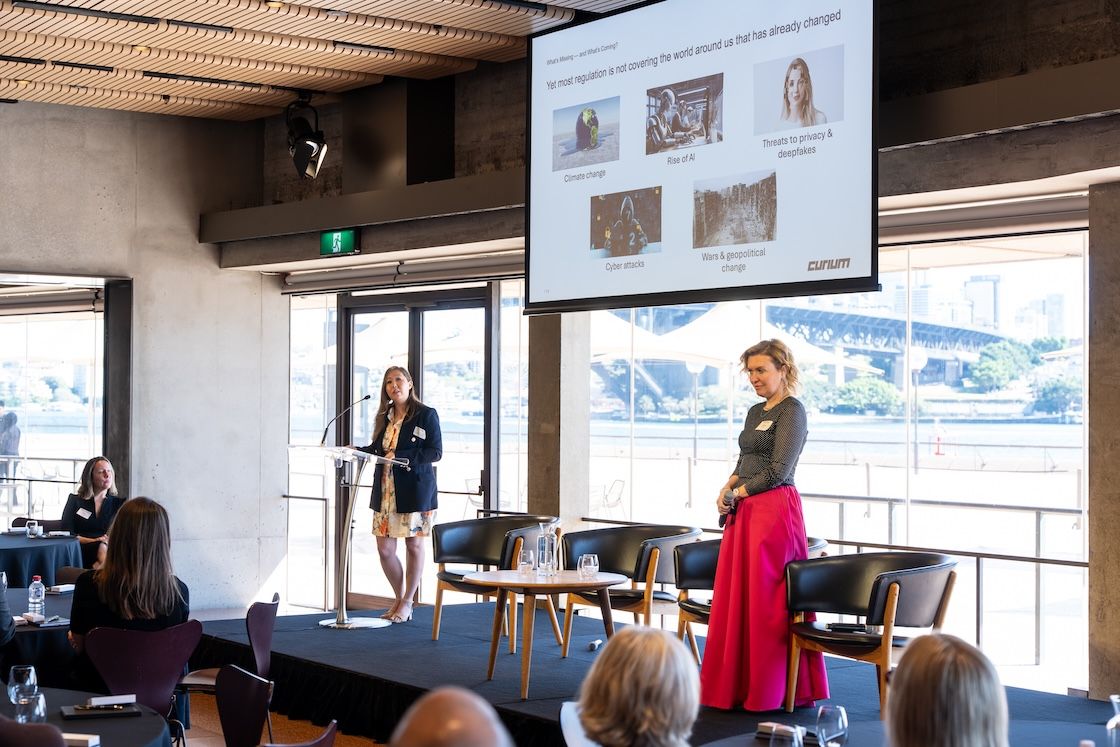 Tetiana George presenting at a Curium event with audience members in a modern venue